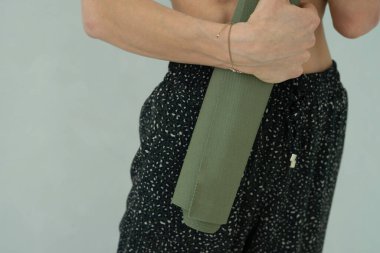 Bir kadının ellerinde yeşil yoga minderi