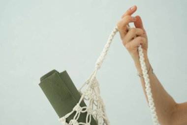 Bir kadının ellerinde yeşil yoga minderi