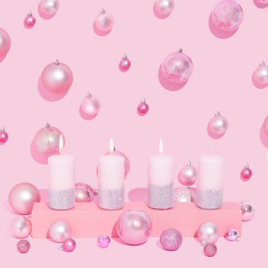 Pembe renkli arkaplanda pembe renkte pembe mumlar. Noel baloları. Üçüncü mum, neşeyi simgeler..
