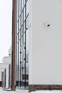 Yeni inşa edilmiş kır evi. Kışın inşaat halindeki bir ev. Yeni inşa edilen modern Beyaz Saray 'ın dışında. Bir apartmanın dış beyaz duvarında güvenlik kamerası var..