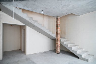 Yeni inşa edilmiş bir binada inşaat halindeki boş bir oda. Kışın inşaat halindeki bir ev. Odanın inşaatı sürüyor. Duvarları alçılı, zemini beton..