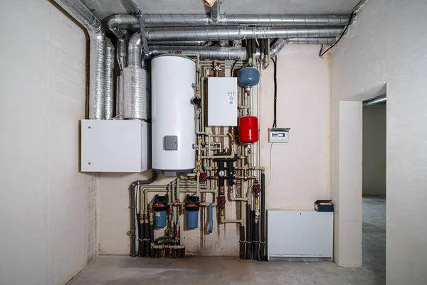 Yeni bir konut binasında ısıtma ve su tedarik sistemi. Boru tesisatı. Odanın inşaatı devam ediyor. Duvarları alçılı, zemini betondan ve tavanı da betondan..