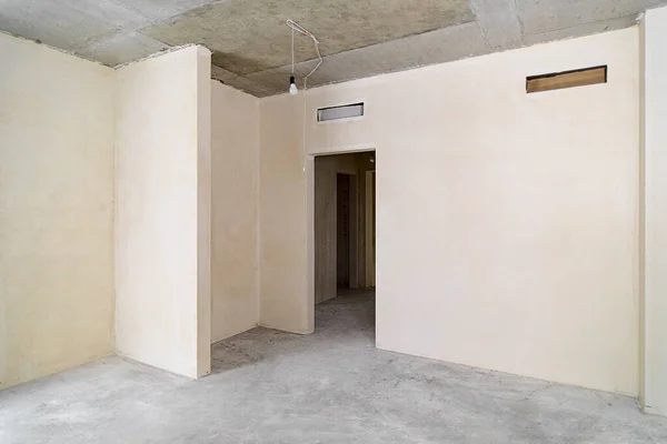 新しい建物の中に建設中の空の部屋 冬に建設中の家 部屋は荒々しい仕上げ 漆喰壁 コンクリートの床で建設中です — ストック写真