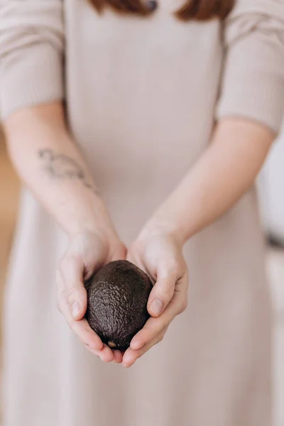 Hands holding fresh avocado. Closeup — Stock Photo, Image