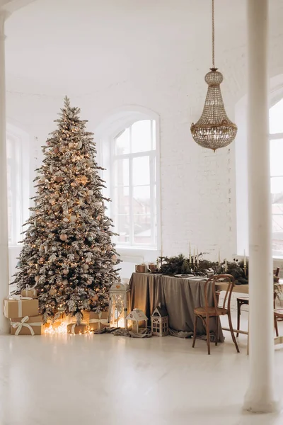 Os presentes de Ano Novo estão abaixo da árvore. Uma árvore coberta de neve perto da lareira. Ano Novo decoração do interior. — Fotografia de Stock