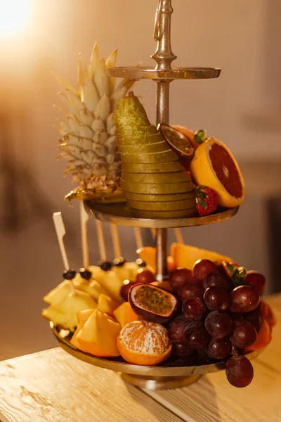 Ωμά φρούτα μούρα πιατέλα, μάνγκο, πορτοκάλια, ακτινίδια φράουλες, Προσκοπίνες γκρέιπ φρουτ σταφυλιών, μπανάνες μήλα στο άσπρο πιάτο, στο off λευκό τραπέζι, το top view, επιλεκτική εστίαση — Φωτογραφία Αρχείου