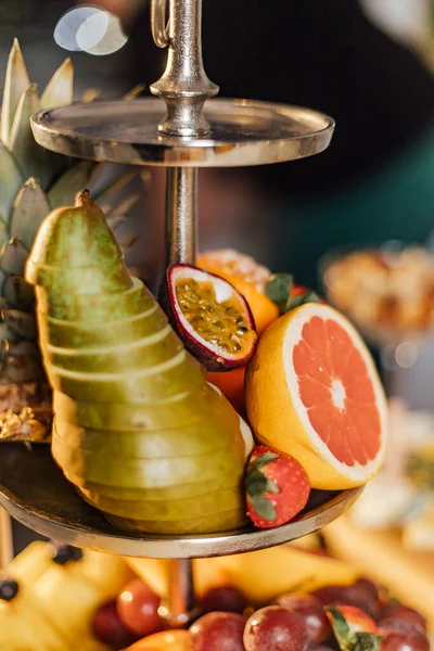 Tropical fruits assortment. tiered fruit platter.pear, pineapple, tangerine, grapes, persimmon, passion fruit — Stock Photo, Image