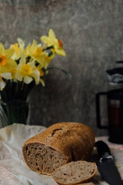 Ahşap masada ev yapımı pişirme için bir somun taze ekmek ve fırın malzemeleri. Tahta döşeme arka planında fotokopi alanı olan fırıncı yiyeceği. Düz üst görünüm.
