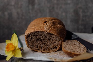 Mad, içinde taze ev yapımı ekmeğin olduğu sepeti tutuyor. Alternatif unlardan sağlıklı ekmek pişirmek.