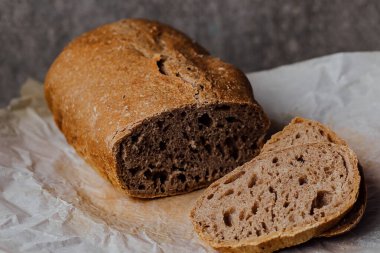 Ekmek, kırsal ahşap arka planda dilimlenmiş geleneksel ekşi ekmek. Geleneksel mayalanmış ekmek pişirme yöntemleri kavramı. Sağlıklı yemek..