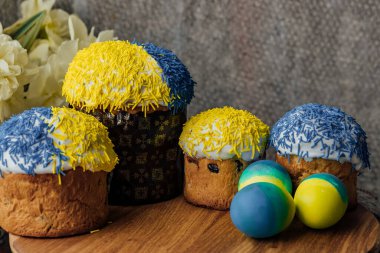 Arka planda çiçekler olan ahşap bir masada lezzetli Paskalya pastaları. mesaj için yer. seçici odak