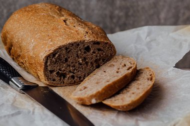 Geleneksel ekşi ekmek, tahta bir tahta üzerinde dilimlenmiş, yakın çekim manzaralı..