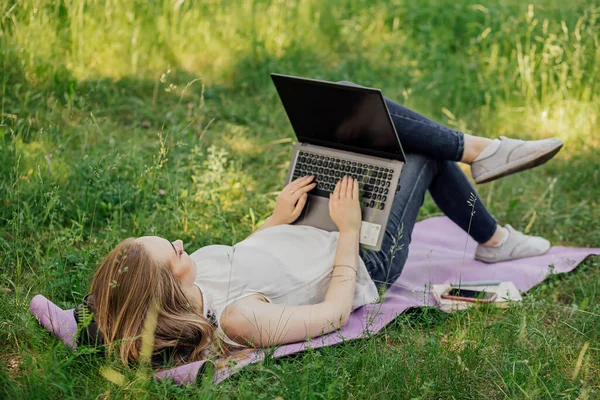 Transparencie Młoda Dziewczyna Pracuje Laptopem Świeżym Powietrzu Parku Siedząc Trawniku — Zdjęcie stockowe