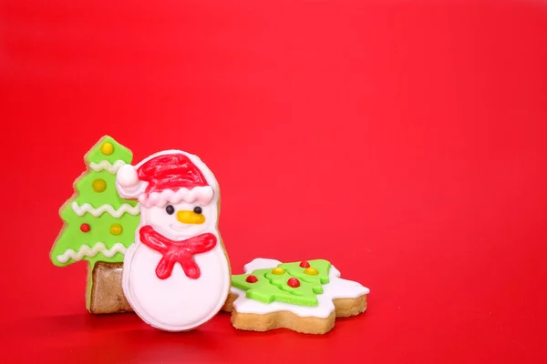 Weihnachtskekse Auf Rotem Hintergrund Weihnachtsgrußkarte Mit Niedlichen Und Bunten Weihnachtskeksen — Stockfoto