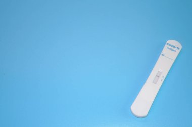 COVID-19 antijen test kiti mavi arka planda izole edildi, kopyalama alanı. Sonuç negatif, ATK