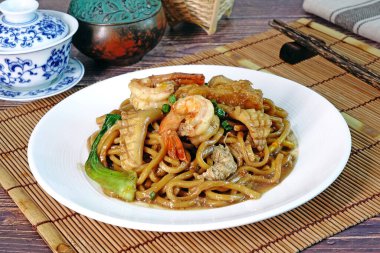 Mee Pad Hokkien veya Karışık Kızarmış Hokkien Mee veya Hokkien Eriştesi. Phuket Orijinal Hokkien Eriştesi deniz ürünleri, domuz eti ve sebzelerle kızartılmış kalın sarı erişteden oluşur. Seçici odak