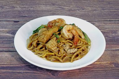 Mee Pad Hokkien veya Karışık Kızarmış Hokkien Mee veya Hokkien Eriştesi. Phuket Orijinal Hokkien Eriştesi deniz ürünleri, domuz eti ve sebzelerle kızartılmış kalın sarı erişteden oluşur. Seçici odak
