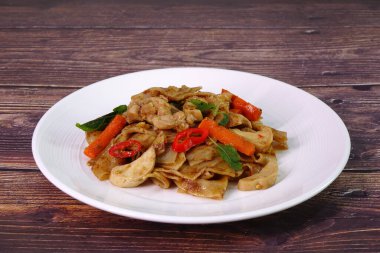 Tayland usulü baharatlı erişteli tavuk ya da tavuklu sarhoş pirinç eriştesi, ünlü Tayland yemeği. Seçici odak, boşluğu kopyala