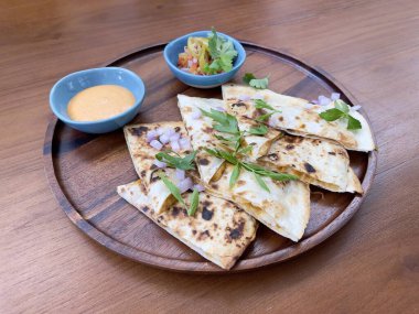 Tavuk quesadilla. Quesadilla, öncelikle peynir, tavuk eti ve baharatla dolu bir Meksika yemeğidir.