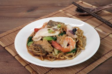 Hokkien Mee (Mee Pad Hokkien) the famous Stir-fried  seafood Noodles. Phuket Original Hokkien Noodles consists of thick yellow (egg) noodles fried with seafood, pork and vegetables. Selective focus