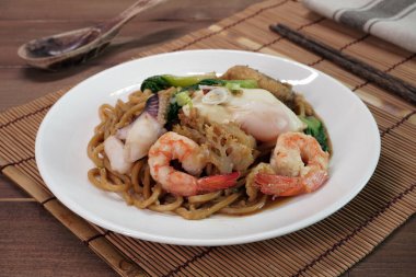 Hokkien Mee (Mee Pad Hokkien) the famous Stir-fried  seafood Noodles. Phuket Original Hokkien Noodles consists of thick yellow (egg) noodles fried with seafood, pork and vegetables. Selective focus