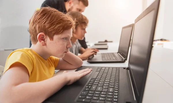 Slimme jongen studeert met laptop in de klas — Stockfoto