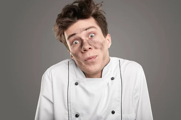 Apologetischer junger Koch mit schmutzigem Gesicht — Stockfoto