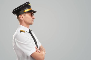 Stüdyoda üniformalı ciddi bir erkek pilot.