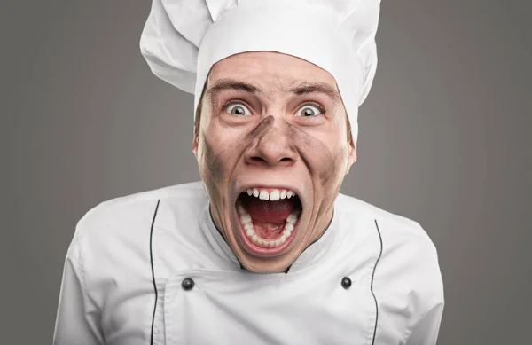 Šílený kuchař se špinavou tváří křičící na kameru — Stock fotografie