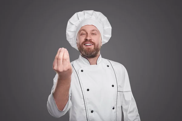 Veselý kuchař ukazuje italské gesto na šedém pozadí — Stock fotografie