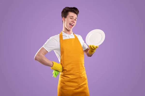 Zufriedene Haushälterin mit Teller auf violettem Hintergrund — Stockfoto