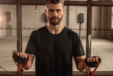 Kırbaç kararlı sporcu spor salonunda direniş bandosu ile çalışıyor.