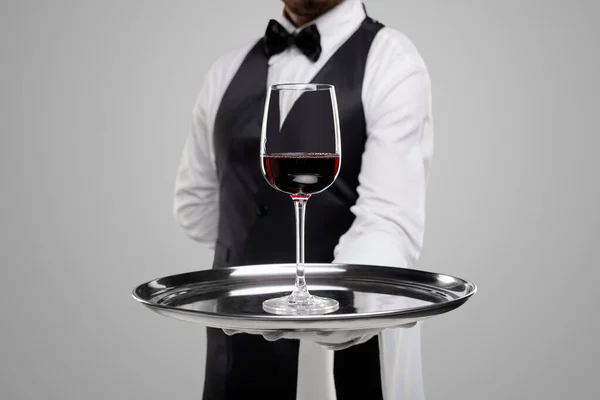 Офіціант пропонує келих вина на підносі — стокове фото