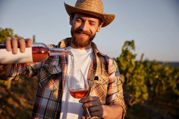 Enólogo derramando vinho em vidro na vinha — Fotografia de Stock