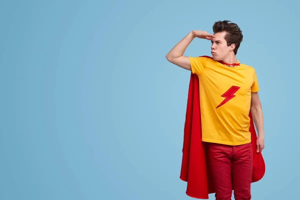 Rolig superhjälte tittar bort i studio — Stockfoto