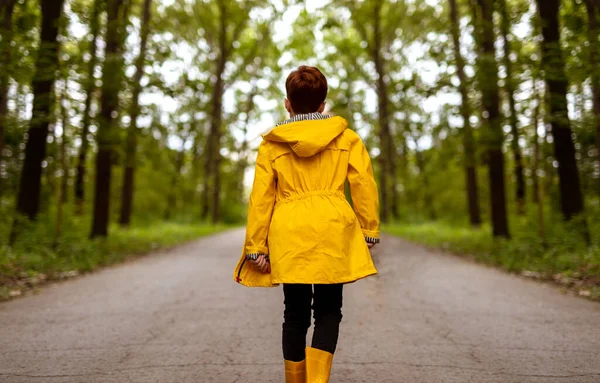 Παιδί με κίτρινο αδιάβροχο στο δάσος — Φωτογραφία Αρχείου