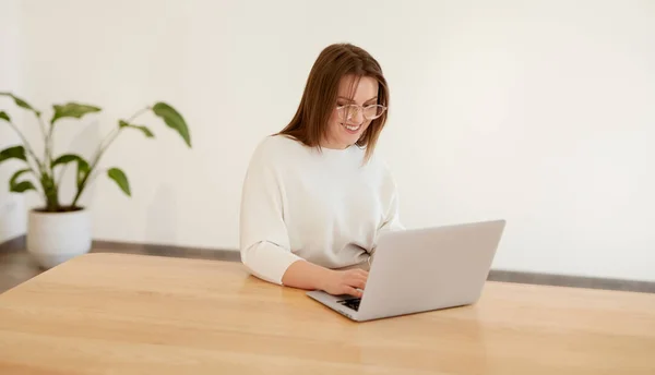 Žena pracující na notebooku v minimalistickém pracovním prostoru — Stock fotografie