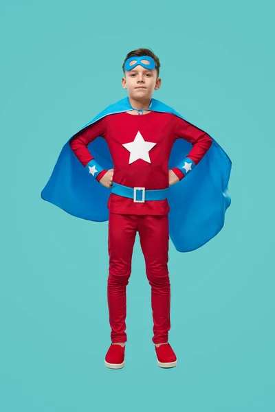 Confident boy in superhero costume
