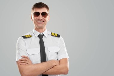 Stüdyoda üniformalı gülümseyen pilot.