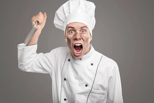 Furious chef with knife in studio — Stock Photo, Image