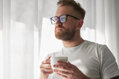Evde sabah kahvesi içen adam.