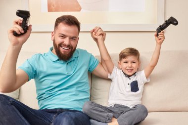 Baba ve oğul birlikte video oyunu oynuyorlar.