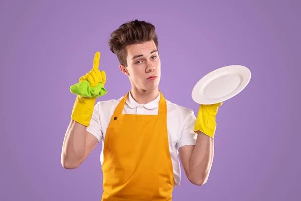 Komische Haushälterin mit sauberem Teller — Stockfoto