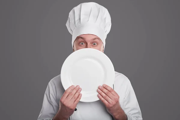 Chef com placa branca olhando para a câmera — Fotografia de Stock