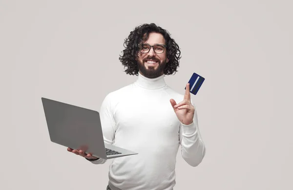 Hombre con tarjeta de plástico y portátil haciendo compras en línea — Foto de Stock