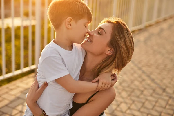 Mãe e filho abraçando e tocando narizes — Fotografia de Stock