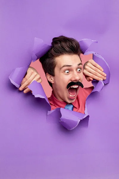 Hombre gracioso gritando a través de papel roto — Foto de Stock