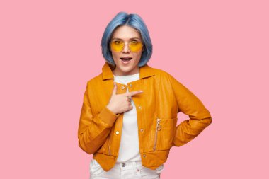 Şok olmuş bir kadın stüdyoyu işaret ediyor.