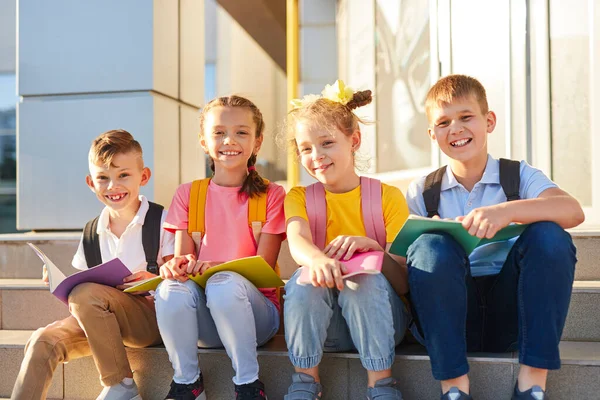 Vrolijke kinderen met schoolboeken op de trap — Stockfoto