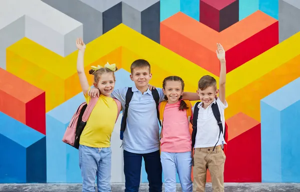 Iskolások csoportja a színes fal ellen — Stock Fotó
